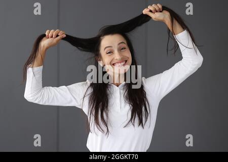 Porträt einer reifen Frau, die lachend ihre Haare aus der Nähe hält Stockfoto