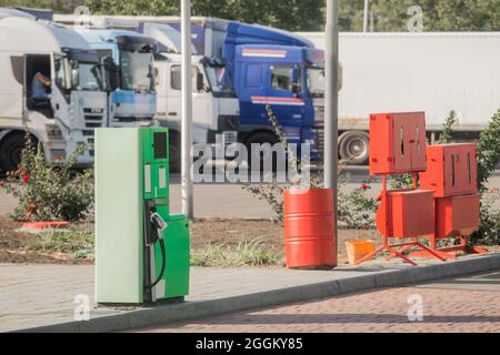 Tankstelle an der Betankung neben dem Feuerwehrkasten mit Werkzeugen und Ausrüstung vor dem Hintergrund eines LKW-Autos. Stockfoto