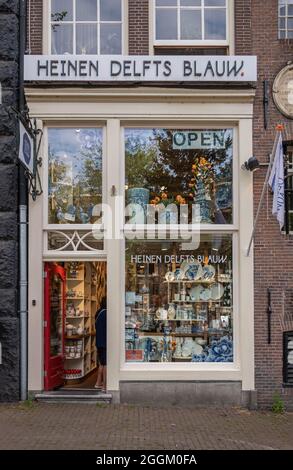 Amsterdam, Niederlande - 13. August 2021: Nahaufnahme des Geschenkeladens Heinen Delfts Blauw an der Prinsengracht 440. Kleines Fenster mit typisch blauem Ceran Stockfoto