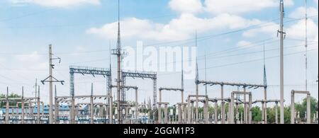 Elektrisches Umspannwerk von Hochspannungsleitungen elektrische Türme vor dem Hintergrund des blauen Himmels. Stockfoto
