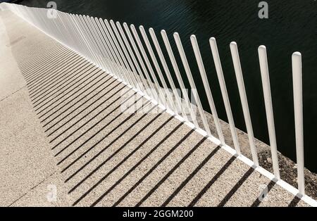 Abstrakter Blick auf den modernen Eisenzaun mit seinem Schatten. Stockfoto