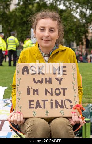 London, Großbritannien. September 2021. Eine Extinction Rebellion Earth Fast Aktivistin sitzt am 5. Tag ihres Hungerstreiks auf dem Parliament Square.das globale Earth Fast für echte Bürger Versammlungen für Klima und Umwelt finden in Städten und Ländern weltweit statt. Sie hat versprochen, nicht zu essen, bis die Regierung zustimmt, eine Bürgerversammlung für die Klima- und Umweltkrise einzurichten (Foto: Dave Rushen/SOPA Images/Sipa USA) Quelle: SIPA USA/Alamy Live News Stockfoto