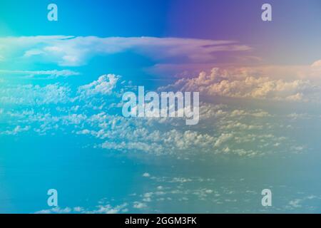 Luftaufnahme aus dem Flugzeug, mit seltsamen Farben, einer Landschaft aus Wolken und fernen Inseln, die über der Insel Sulawesi, Indonesien, fliegen Stockfoto