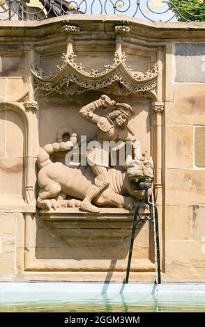 Deutschland, Baden-Württemberg, Schwäbisch Hall, St. Georg tötet am gotischen Fischbrunnen den Lindenwurm, eine Brunnenfigur aus dem Jahr 1509 des Bildhauers Hans Beuscher. Stockfoto
