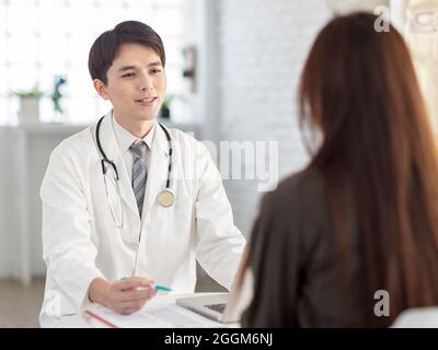 Junger Arzt im Gespräch mit dem Patienten. Stockfoto