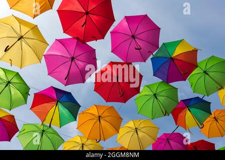 Bunte Regenschirme vor blauem Himmel in Masevaux im Elsass, Frankreich Stockfoto