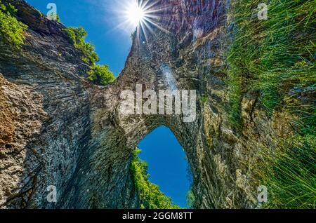 Blick von der Natural Bridge mit einem Sonnenstern dahinter auf den Natural Bridge State Park in Virginia. Stockfoto