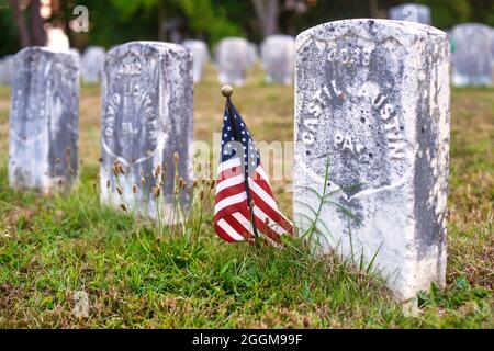 Eine kleine amerikanische Flagge markiert die Gräber von Unionstoten auf dem Antietam National Cemetery in Sharpesburg, Maryland. Stockfoto