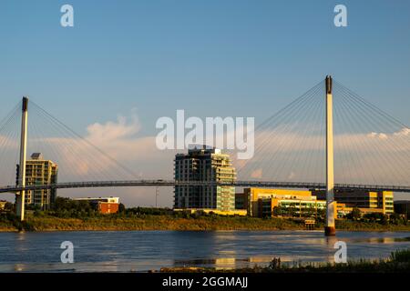 Bob Kerrey Fußgängerbrücke und Riverfront Place an einem wunderschönen Morgen. Aufgenommen aus Tom Hanafan River's Edge Park, Council Bluffs, Iowa, USA. Stockfoto