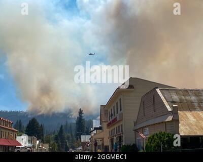 Rauch von der Main Street aus gesehen, Greenville das Dixie Fire ist ein Waldbrand, der Greenville, Kalifornien, zu Boden verbrannte und bis Ende August 2021 in den kalifornischen Grafschaften Butte, Plumas und Tehama 844,082 Acres Land verbrannt hat. Der Brand, der am 13. Juli 2021 begann, ist der größte aufgezeichnete Brandkomplex in der Geschichte Kaliforniens. Die Dürrebedingungen in Kalifornien haben die Feuersaison 2021 extrem gemacht. Stockfoto