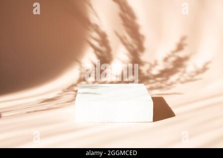 Leeres Podium für die Präsentation von Kosmetikprodukten. Schatten und Silhouette von Pampagras auf dem Hintergrund - Bild Stockfoto