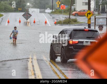 Wilkes Barre, Usa. September 2021. Ein Mädchen geht durch die geschlossene und überflutete Main Street, nachdem Regen Blitzüberflutungen im gesamten Nordosten von Pennsylvania verursacht hat. Die Überreste des Sturmgebetes Ida ziehen die Ostküste hinauf und verursachen Überschwemmungen und Evakuierungen in niedrig gelegenen Gemeinden. Der Susquehanna River fließt durch die Innenstadt, wie auch viele Bäche, die oft Grund zur Sorge wegen Überschwemmungen waren. Kredit: SOPA Images Limited/Alamy Live Nachrichten Stockfoto