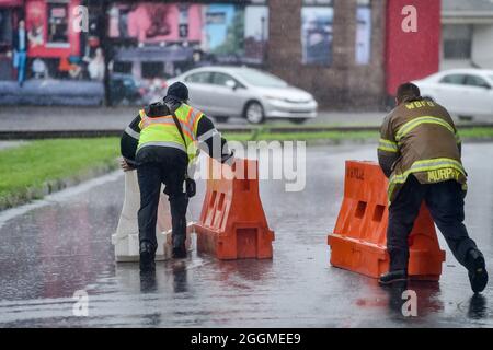 Wilkes Barre, Usa. September 2021. Feuerwehrleute verschieben aufgrund von Überschwemmungen Barrikaden, um eine Straße zu schließen. Die Überreste des Sturmgebetes Ida ziehen die Ostküste hinauf und verursachen Überschwemmungen und Evakuierungen in niedrig gelegenen Gemeinden. Der Susquehanna River fließt durch die Innenstadt, wie auch viele Bäche, die oft Grund zur Sorge wegen Überschwemmungen waren. (Foto von Aimee Dilger/SOPA Images/Sipa USA) Quelle: SIPA USA/Alamy Live News Stockfoto