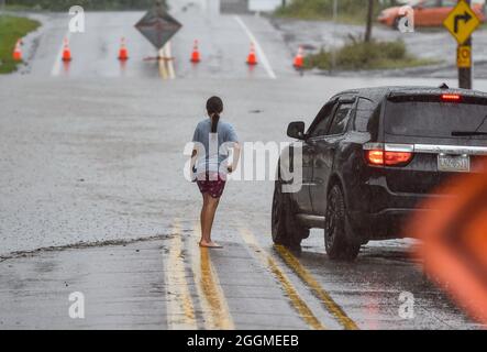 Wilkes Barre, Usa. September 2021. Ein Mädchen spricht mit einem Fahrer, nachdem sie eine überflutete Hauptstraße überquert hat. Die Überreste des Sturmgebetes Ida ziehen die Ostküste hinauf und verursachen Überschwemmungen und Evakuierungen in niedrig gelegenen Gemeinden. Der Susquehanna River fließt durch die Innenstadt, wie auch viele Bäche, die oft Grund zur Sorge wegen Überschwemmungen waren. (Foto von Aimee Dilger/SOPA Images/Sipa USA) Quelle: SIPA USA/Alamy Live News Stockfoto