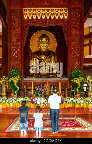 Eine buddhistische Familie betet zum Geburtstag Buddhas vor der Haupthalle eines alten Tempels in Ho Chi Minh City, Vietnam, für den Frieden Stockfoto