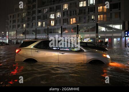 New York City, USA. September 2021. Ein Auto sitzt in einer überfluteten Straße in der Nähe des Queens Boulevard, verursacht durch Sturzflutungen, die durch die Überreste des Hurrikans Ida im New Yorker Stadtteil Queens, NY, am 1. September 2021 verursacht wurden. Mehr als 5 cm Regen fielen pro Stunde, was dazu führte, dass das U-Bahnsystem von New York City vorübergehend eingestellt wurde. (Foto von Anthony Behar/Sipa USA) Quelle: SIPA USA/Alamy Live News Stockfoto