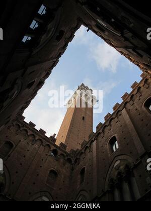 Der historische Torre del Mangia von Siena, Italien - fertiggestellt im Jahr 1348 - wird tagsüber vom Innenhof des Palazzo Pubblico (Rathaus) aus gezeigt. Stockfoto