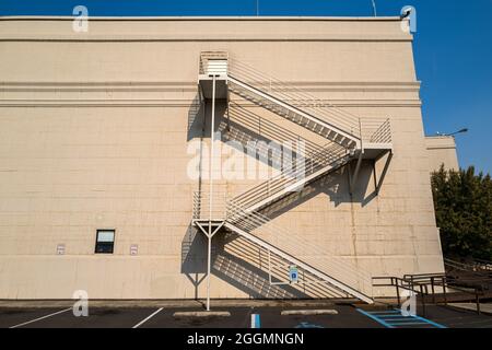 Eine Feuertreppe wirft Schatten auf die Wand eines Gebäudes Stockfoto