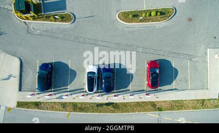 Drone-Ansicht von Tesla-Fahrzeugen, die an einem sonnigen Tag an einem Tesla-Supercharger-Standort geladen werden. Stockfoto