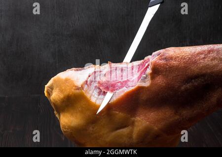 Jamon. Jamon serrano. Traditioneller spanischer Schinken auf schwarzem Nahaufnahme. Stockfoto