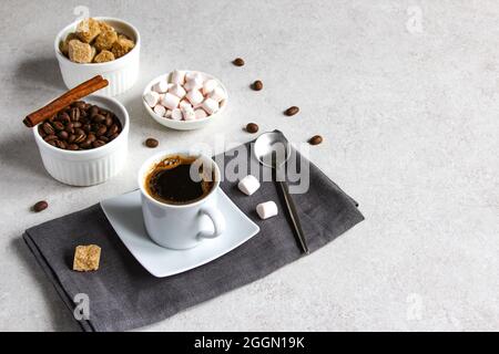 Vanillekaffee mit braunem Zucker und Moormarmelow. Leckerer Dampf-Espresso in einer Tasse mit Kaffeebohnen. Stockfoto