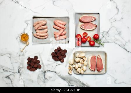 Verschiedene Fleischstücke auf Marmorboden Stockfoto