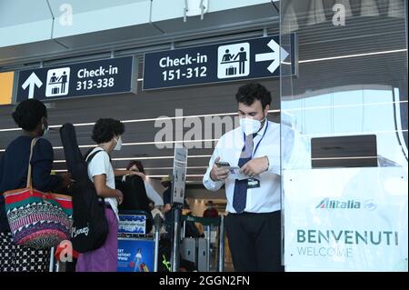 Rom, Italien. September 2021. Ein Mitarbeiter überprüft am 1. September 2021 den grünen Pass COVID-19 eines Passagiers auf dem Flughafen Fiumicino in Rom, Italien. Der grüne Pass COVID-19 wurde am Mittwoch in Italien für Langstreckentransporte wie Flugzeuge, Schiffe, Fähren und Züge obligatorisch. Der grüne Pass ist ein Zertifikat der italienischen Gesundheitsbehörden, das zeigt, dass Menschen geimpft wurden oder negativ getestet wurden oder sich von COVID-19 erholt haben. Quelle: Alberto Lingria/Xinhua/Alamy Live News Stockfoto