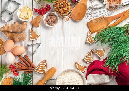 Kulinarischer Hintergrund mit Ingwerkeksen und Zutaten auf weißem Hintergrund Stockfoto