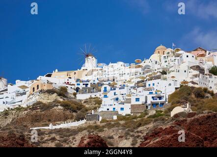 Blick auf typische weiße Gebäude in den Klippen von Oia, Santorini, einer griechischen Mittelmeerinsel der Kykladen-Gruppe, von der Ammoudi-Bucht aus gesehen Stockfoto