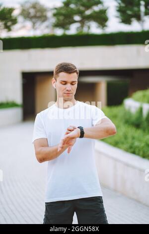 Athlet Runner mit Blick auf die Uhr des Herzfrequenzsensors. Mann überprüft sein Gadget vor dem Laufen Stockfoto