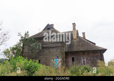 Ein altes, verlassene, dreigeschossige, komplett aus Holz gefertigte Haus mit Ofenheizung. Stockfoto