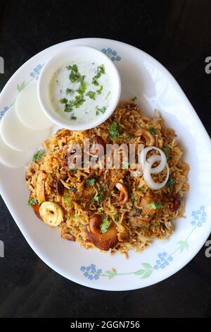 Huhn Biryani oder Murgh Pulao. Garniert mit gebratener Zwiebel, Cashewkernen und Koriander. Biryani ist ein berühmtes würziges, nicht-vegetarisches Gericht Indiens. Stockfoto