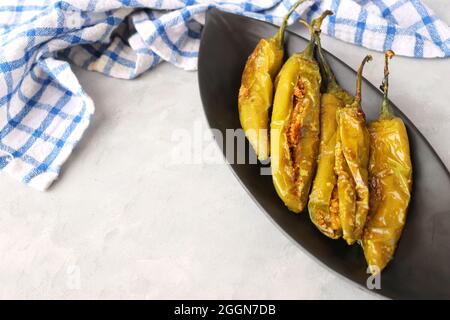 Gefüllte grüne Chilischoten, Bharwa Masala Mirch oder Bharli Mirchi, Sandgi Mirchi. Serviert auf einem schwarzen Teller auf einem hellen Hintergrund. Speicherplatz kopieren. Stockfoto