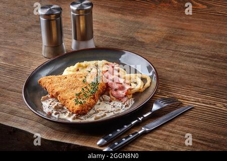 Hähnchen Schnitzel mit Kraut, Kartoffelpüree und Champignons Soße auf Platte auf hölzernen Tisch Hintergrund. Gesundes Essen. Stockfoto