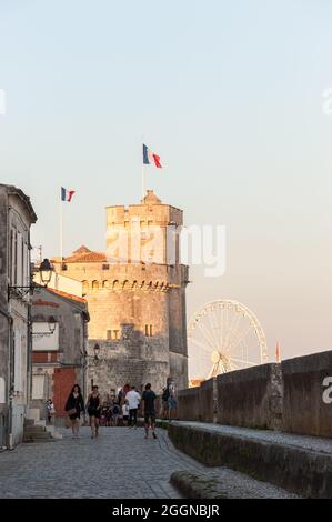 La Rochelle, Frankreich; 10. August 2021: Spaziergang entlang der Stadtmauer im alten mittelalterlichen Hafen von La Rochelle, Frankreich. Touristen werden auf einem sonnigen Spaziergang gesehen Stockfoto