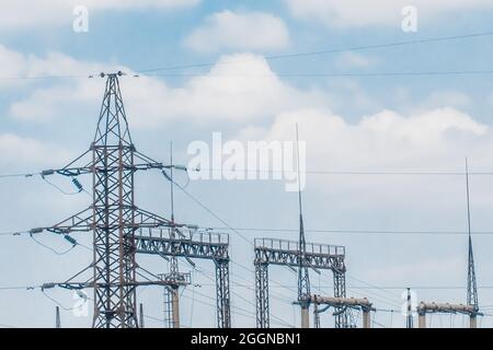 Elektrisches Umspannwerk von Hochspannungsleitungen elektrische Türme vor dem Hintergrund des blauen Himmels. Stockfoto