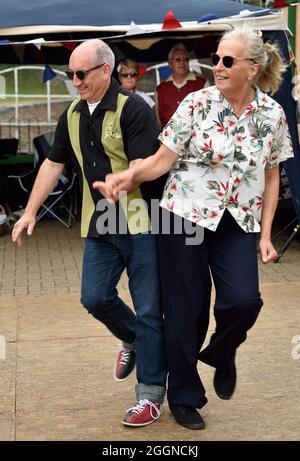 Ein Paar in Retro-Kleidung tanzt während eines Wochenendes in der Watercress Line, Alresford, Hampshire, Großbritannien. Stockfoto