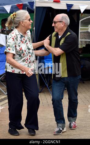 Ein Paar in Retro-Kleidung tanzt während eines Wochenendes in der Watercress Line, Alresford, Hampshire, Großbritannien. Stockfoto