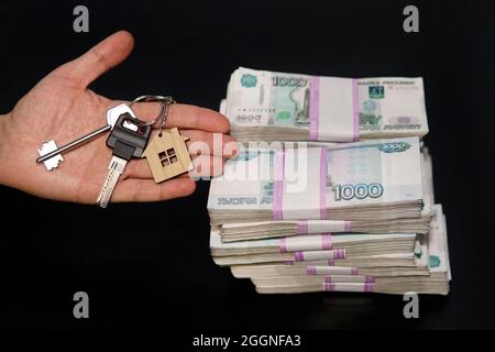 Paket von fünftausend Notizen mit Schlüsseln zu einer Wohnung oder einem Haus auf weißem Hintergrund. Kauf von Immobilien für russisches Geld. Immobilientransaktion Stockfoto