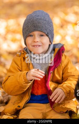 Ein Kind freut sich, mit einem Marienkäfer in einem Herbstpark zu spielen. Frohe Kindheit. Stockfoto