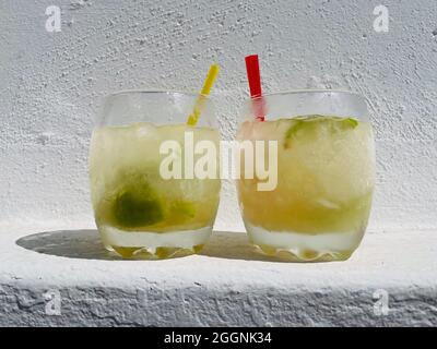 Caipirinha gegen Caipirinhas. Alkoholisches Erfrischungsgetränk aus Brasilien mit Eis, Limette, Kakao und Zucker. Stockfoto