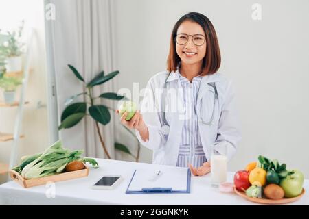 Porträt der Jungen lächelnd weibliche Ernährungsberaterin in der Beratung. Ernährungsberater arbeiten an Diätplan. Stockfoto