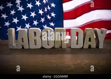 Banner zum Happy Labor Day. USA Flagge und Buchstaben auf rustikalem Holzhintergrund. Stockfoto