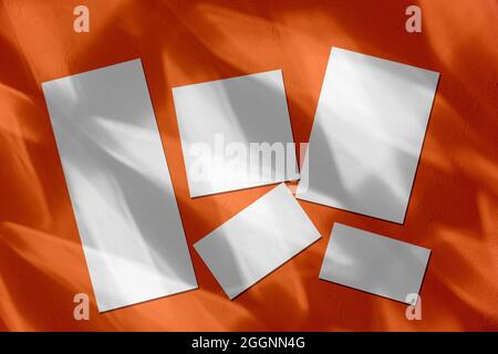 Leere Hochzeitspapiermockups mit Schatten auf orangefarbenem Hintergrund Stockfoto