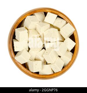 Würfel aus weißem Tofu, in einer Holzschale. Gewürfelter Bohnenquark, gerinnte Sojamilch, in weiße Blöcke unterschiedlicher Weichheit gepresst. Stockfoto