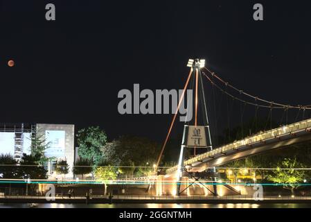 Blood Moon (Mondfinsternis) über dem berühmten Städel Museum in Frankfurt, Deutschland mit einem Boot, das auf dem Fluss vorbeifährt, sichtbar als Lichtlinien im langen AP. Stockfoto