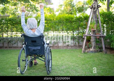 Asiatische ältere oder ältere alte Dame Frau Patient Übung im Rollstuhl mit glücklich frisch genießen im Hausgarten, gesund starke medizinische Konzept Stockfoto