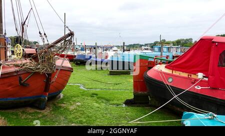 Woodbridge, Suffolk, Großbritannien - 2. September 2021: Bunte Hausboote und leuchtend grüner Schlamm bei Ebbe. Stockfoto