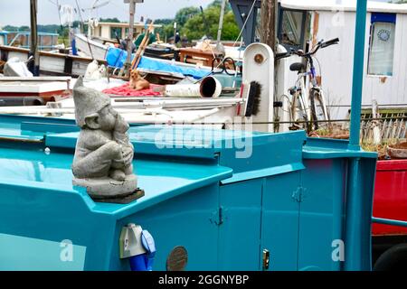 Woodbridge, Suffolk, Großbritannien - 2. September 2021: Nachdenklicher Zwerg auf einem Hausbootdach. Stockfoto