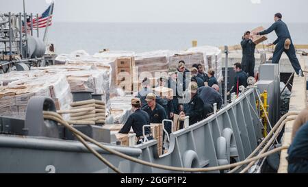 US-Matrosen mit Joint Task Force-Haiti (JTF-Haiti) helfen bei der Auslagerung von Verteilerkästen in Port of Jeremie, Haiti, 31. August 2021. Die Marineinfanteristen und Seeleute an Bord der USS Arlington (LPD 24) haben sich für die Unterstützung der JTF-Haiti für eine humanitäre Hilfe und Katastrophenhilfe eingesetzt. (USA Marine Corps Foto von Lance CPL. Jacqueline C. Arre) Stockfoto